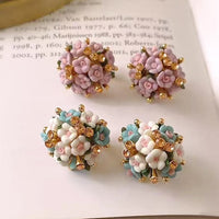 Blooming Rose Bouquet Ceramic Earrings featuring handcrafted ceramic roses, sparkling crystal accents, and rose gold-plated brass. Available in lilac or light blue for timeless vintage-inspired elegance.