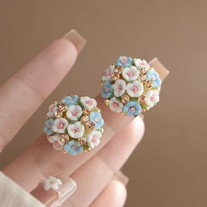Blooming Rose Bouquet Ceramic Earrings featuring handcrafted ceramic roses, sparkling crystal accents, and rose gold-plated brass. Available in lilac or light blue for timeless vintage-inspired elegance.