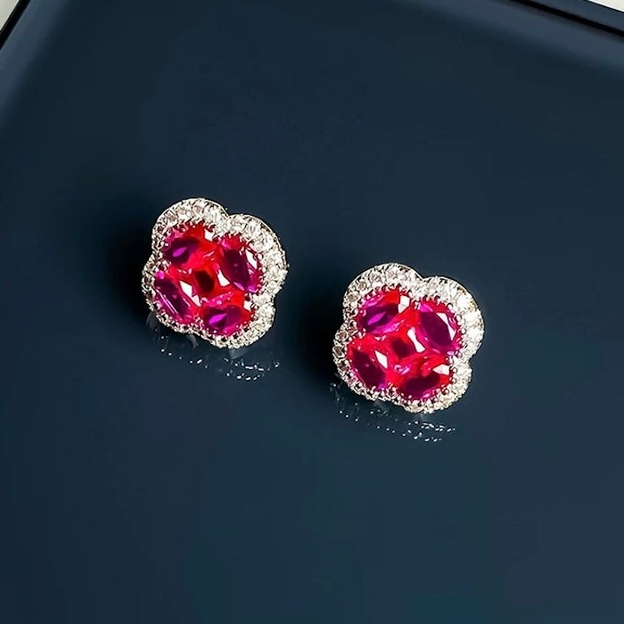 Vivid Ruby Flower Jewelry Set featuring ruby-red floral zirconias surrounded by sparkling crystal halos, including matching stud earrings and an adjustable ring.

