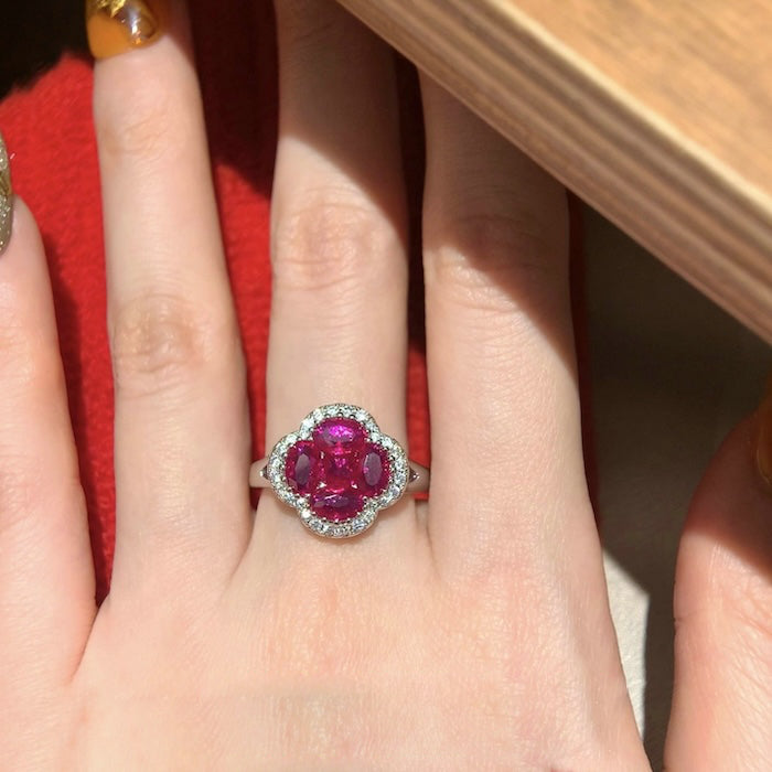Vivid Ruby Flower Jewelry Set featuring ruby-red floral zirconias surrounded by sparkling crystal halos, including matching stud earrings and an adjustable ring.
