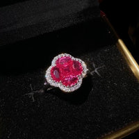 Vivid Ruby Flower Jewelry Set featuring ruby-red floral zirconias surrounded by sparkling crystal halos, including matching stud earrings and an adjustable ring.
