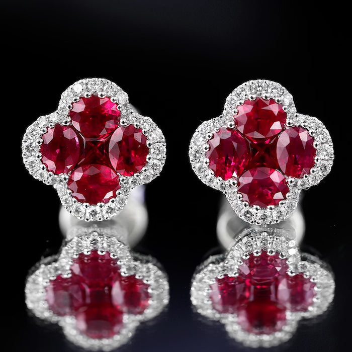 Vivid Ruby Flower Jewelry Set featuring ruby-red floral zirconias surrounded by sparkling crystal halos, including matching stud earrings and an adjustable ring.
