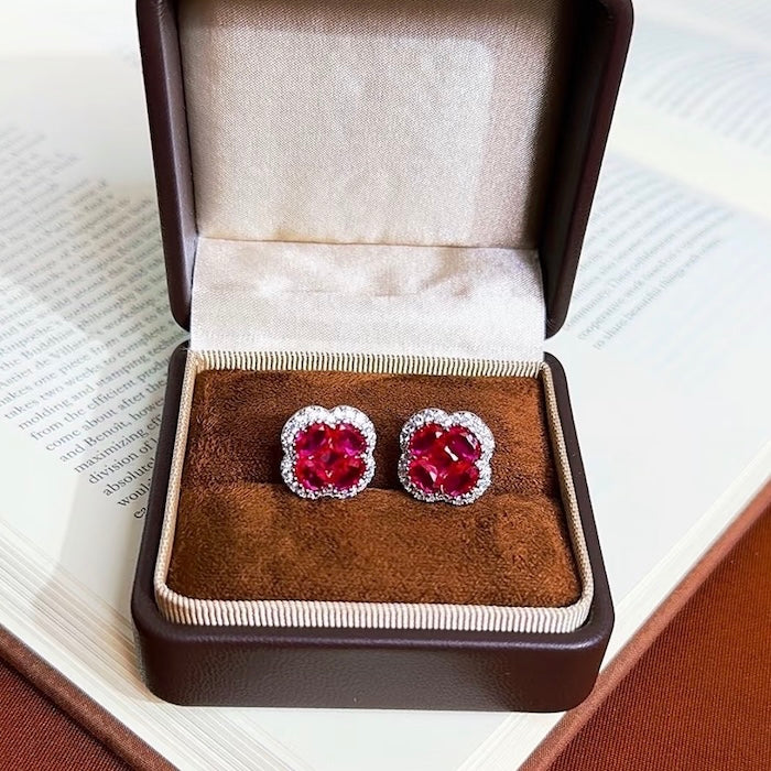 Vivid Ruby Flower Jewelry Set featuring ruby-red floral zirconias surrounded by sparkling crystal halos, including matching stud earrings and an adjustable ring.
