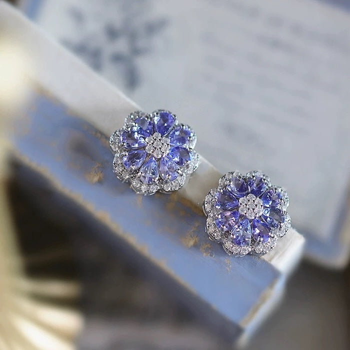 Tanzanite Blossom Halo Stud Earrings with genuine pear-cut tanzanite, cubic zirconia halo and sterling silver floral setting.
