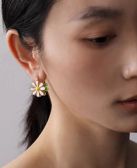 Golden Twin Daisy Hoop Earrings featuring one green enamel daisy and one soft pink enamel daisy suspended from polished gold-tone hoops.