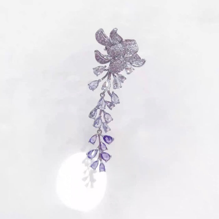 Dazzling Wisteria Flower Tassel Earrings featuring sparkling floral zirconia details and cascading lavender-toned crystal tassels in a silver-tone setting.
