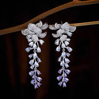 Dazzling Wisteria Flower Tassel Earrings featuring sparkling floral zirconia details and cascading lavender-toned crystal tassels in a silver-tone setting.
