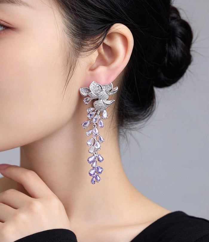 Dazzling Wisteria Flower Tassel Earrings featuring sparkling floral zirconia details and cascading lavender-toned crystal tassels in a silver-tone setting.
