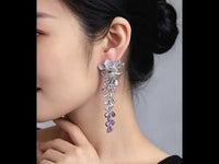 Dazzling Wisteria Flower Tassel Earrings featuring sparkling floral zirconia details and cascading lavender-toned crystal tassels in a silver-tone setting.
